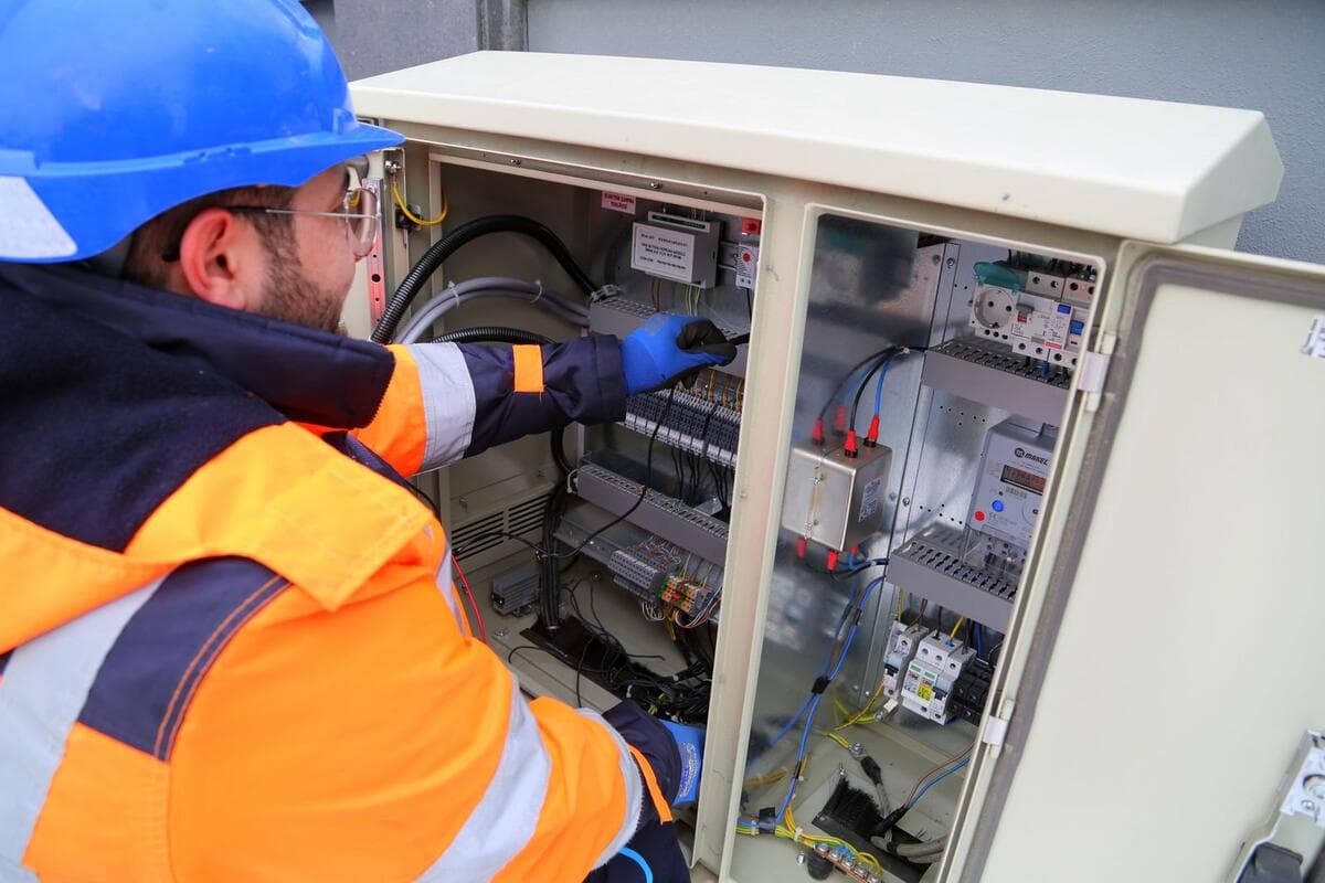 Como reduzir visitas que não viram serviço Eletricista avaliando um quadro elétrico antes de passar orçamento