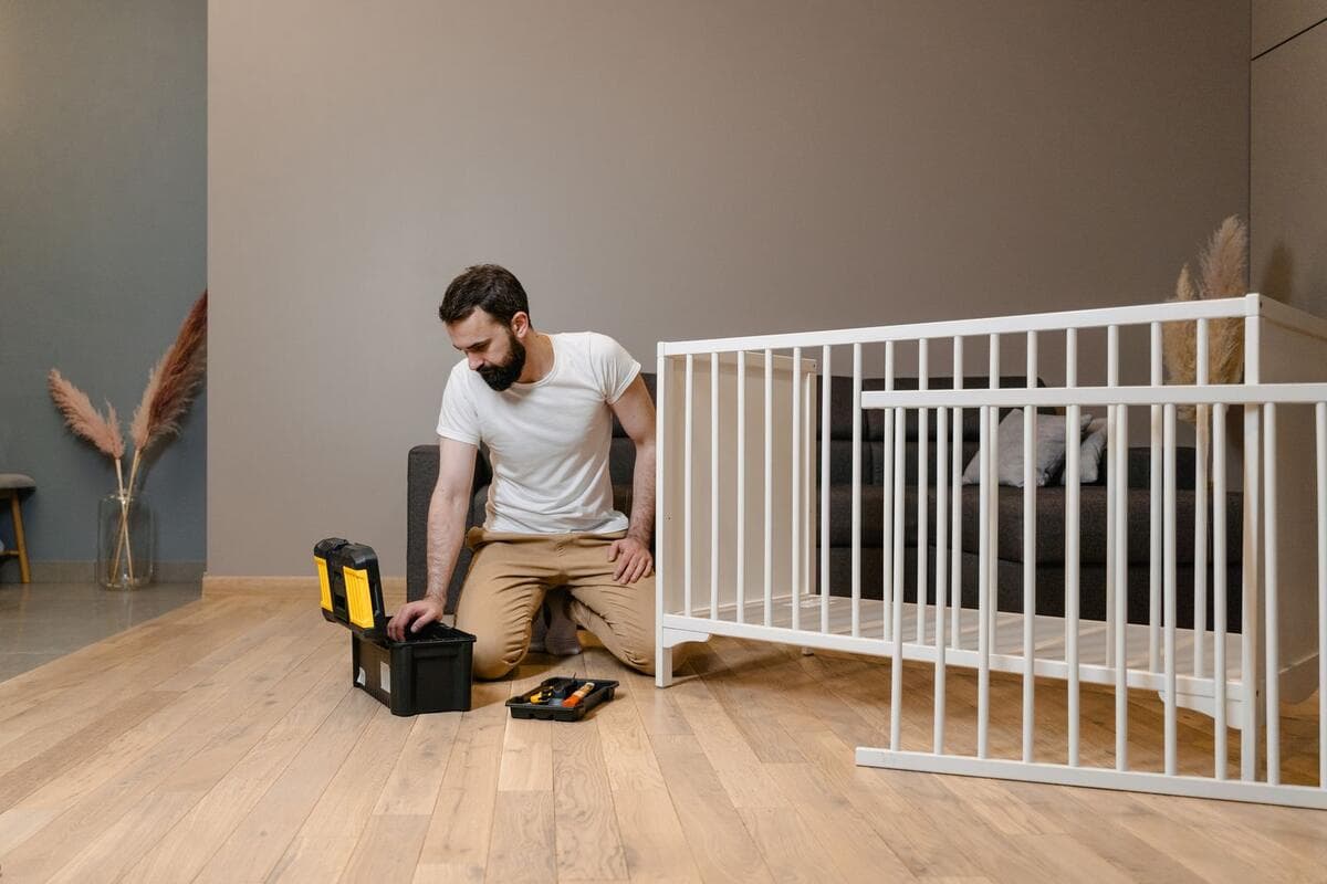 Como escolher o montador Homem montando um berço branco com ferramentas na sala