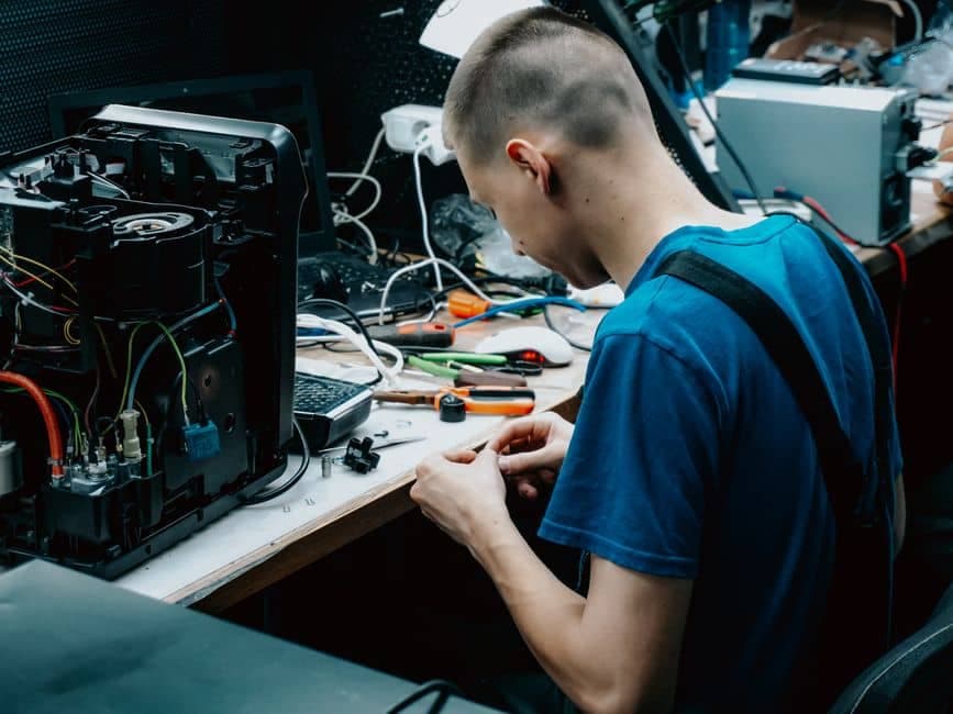 Técnico consertando um aparelho eletrônico em oficina