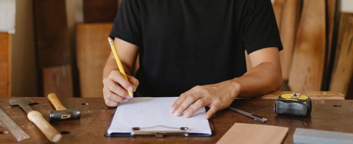 Profissional desenhando o projeto do serviço no papel antes de montar o orçamento