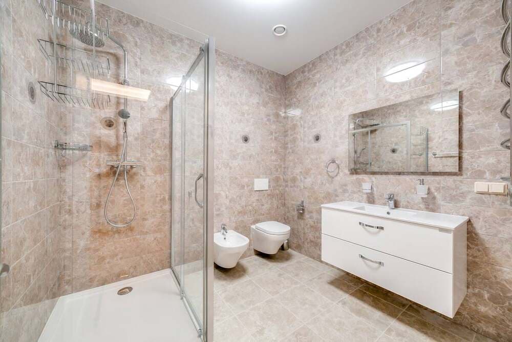 Banheiro moderno com box de vidro e acabamentos minimalistas