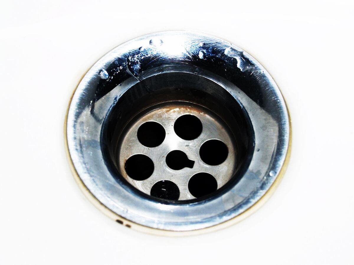 Como prevenir e quando chamar um profissional Ralo de metal com gotas de água