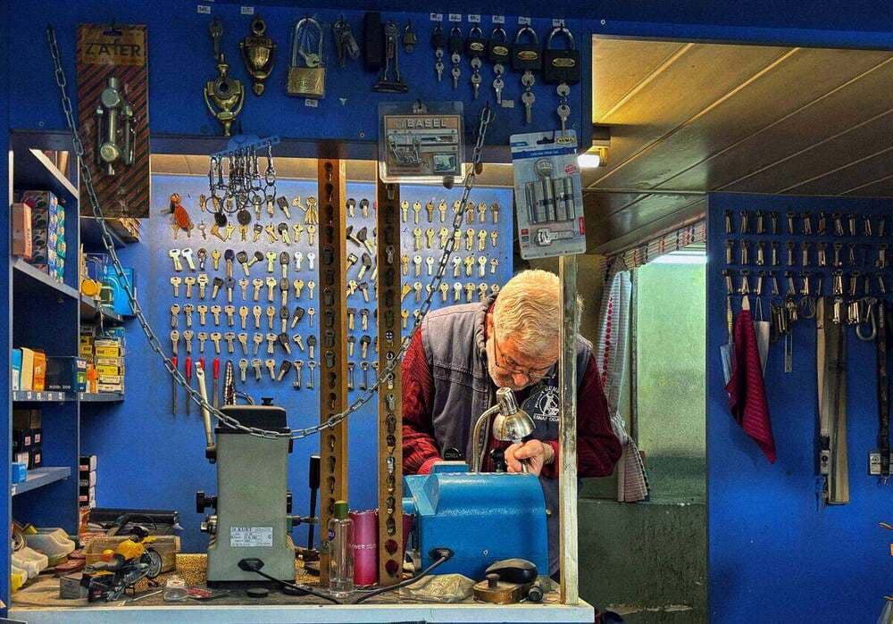 Chaveiro fazendo cópia de chave em sua oficina